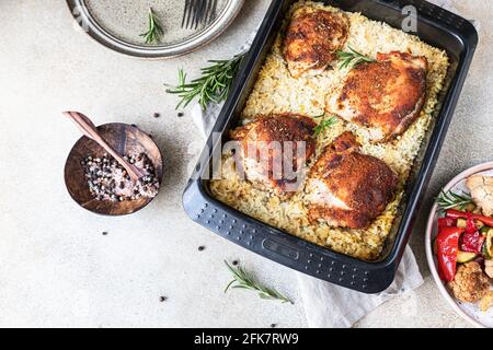 Carne di pollo al forno con riso in un piatto da forno servito con verdure arrostite. Carne di pollo al forno con riso. Vista dall'alto. Messa a fuoco selettiva. Foto Stock