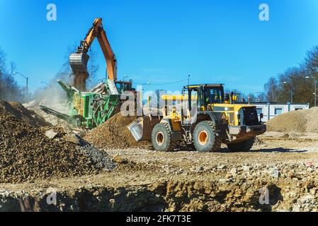 Escavatore e macchina rasatrice in cantiere. Foto Stock