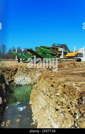 Escavatore e macchina rasatrice in cantiere. Foto Stock