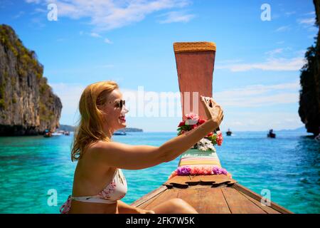 Una bella donna che prende un selfie nella Laguna di Pileh una destinazione popolare nel gruppo delle isole Phi Phi. Foto Stock