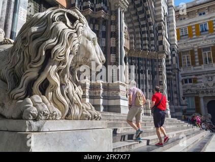 Genova, Liguria, Italia. Cattedrale gotica di San Lorenzo. I turisti camminano sui gradini per entrare oltre il leone. Foto Stock
