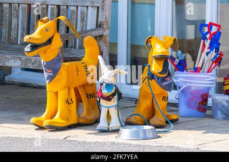 Lyme Regis, Dorset, Regno Unito. 29 Apr 2021. Regno Unito Meteo. Famiglia di cani RNLI Lifeboat fatta di gialle al di fuori del negozio di beneficenza RNLI a Lyme Regis in una giornata di sole. Le associazioni di beneficenza hanno sofferto di ripetuti blocchi e restrizioni che limitano i visitatori. Credit: Celia McMahon/Alamy Live News Foto Stock