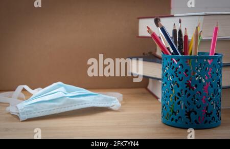 Forniture scolastiche e maschera di prevenzione COVID 19. Ritorno a scuola durante il concetto pandemico Foto Stock