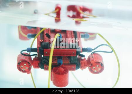 Primo piano immagine di sfondo di un'imbarcazione robotica rossa con telecamera in serbatoio d'acqua presso il laboratorio di ingegneria e robotica, spazio di copia Foto Stock