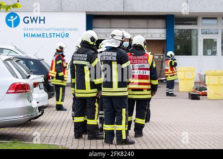 29 aprile 2021, bassa Sassonia, Hildesheim: I vigili del fuoco si trovano all'esterno di una grande lavanderia durante un'operazione. Un barile gonfiato da 200 litri con sostanze chimiche in una lavanderia a Hildesheim ha innescato un'operazione di vigili del fuoco. La sostanza chimica era ipoclorito di sodio - un agente sbiancante e disinfettante. Foto: Julian Stratenschulte/dpa Foto Stock