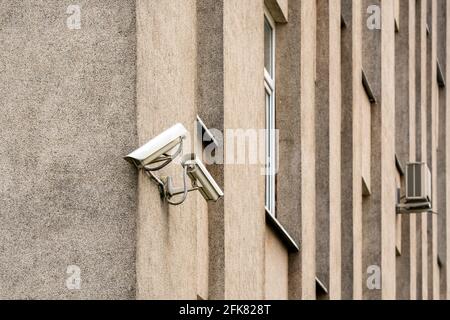 Due telecamere TVCC sulla parete grigia dell'edificio. Sistema di sicurezza CCTV. Foto Stock