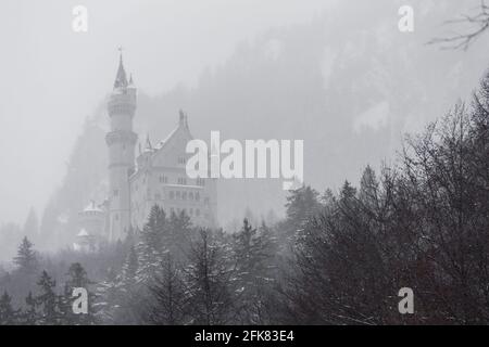 Schwangau, Germania - 27 dicembre 2014: Cima del castello di Neuschwanstein in una giornata misteriosa sulla città di Schwangau, Germania. Foto Stock