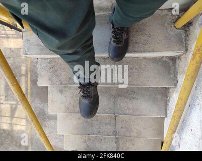 Uomo in scarpe sportive scendendo le scale Foto Stock