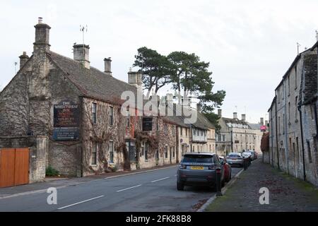 Una strada con case e un pub locale chiamato il Wheatsheaf a Northleach, Gloucester, Inghilterra Foto Stock
