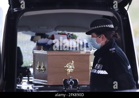 Un poliziotto si trova accanto alla bara di Stirling crematorio, al funerale del ciclista Anthony Parsons, il cui corpo è stato trovato tre anni dopo la sua scomparsa. L'ex ufficiale della Marina militare, noto anche come Tony, è andato perso 63 anni nel 2017, mentre in un lungo ciclo di beneficenza dalla sua casa a Tillicoultry, Clackmannanshire, a Fort William. Data immagine: Giovedì 29 aprile 2021. Foto Stock