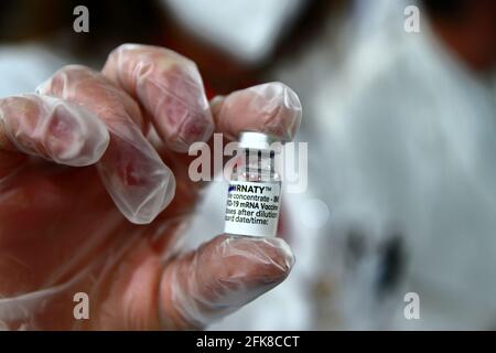 Allinterno della farmacia mentre si prepara una siringa per la somministrazione del vaccino astrazeneca. Dettaglio del flacone contenente il vaccino. Foto Stock