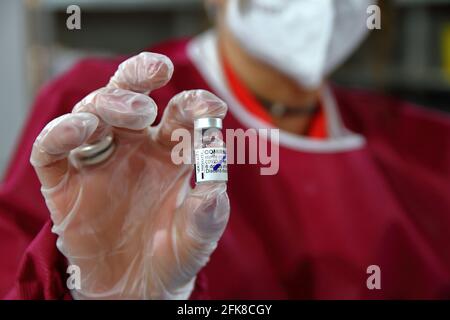 Allinterno della farmacia mentre si prepara una siringa per la somministrazione del vaccino astrazeneca. Dettaglio del flacone contenente il vaccino. Foto Stock