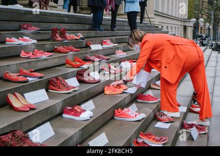 29 aprile 2021, bassa Sassonia, Hannover: Thela Wernstedt (SPD), portavoce della politica femminile del gruppo parlamentare SPD, mette un paio di scarpe sulle scale di fronte al parlamento della bassa Sassonia durante la campagna "Scarpe rosse" contro il ritiro della Turchia dalla Convenzione di Istanbul. Ogni paio di scarpe è sinonimo di una donna morta per violenza. Il colore rosso indica il sangue versato. La forma d'azione risale all'artista messicano Elina Chauvet, che ha lanciato il progetto 'Zapatos Rojos' ('Red Shoes') nel 2009 e ha già fatto azioni con scarpe rosse in vari paesi t Foto Stock