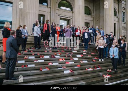 29 aprile 2021, bassa Sassonia, Hannover: I membri del parlamento di Stato si trovano di fronte al parlamento di Stato della bassa Sassonia durante la campagna "Scarpe rosse" contro il ritiro della Turchia dalla Convenzione di Istanbul. Ogni paio di scarpe è sinonimo di una donna morta per violenza. Il colore rosso indica il sangue versato. La forma d'azione risale all'artista messicano Elina Chauvet, che ha lanciato il progetto 'Zapatos Rojos' ('Red Shoes') nel 2009 e ha già effettuato azioni con scarpe rosse in vari paesi per commemorare le donne scomparse, abusate, violentate e assassinate. Foto: OLE Spata Foto Stock