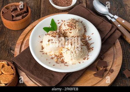 Dessert estivo rinfrescante su sfondo marrone. Gelato al cioccolato e biscotti sbriciolati. Foto Stock