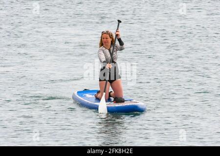 West Bay, Dorset, Regno Unito. 29 aprile 2021. Regno Unito Meteo. Un paddle boarder godendo il mare calmo presso la località balneare di West Bay in Dorset, il giorno di nuvole e caldi incantesimi di sole. Picture Credit: Graham Hunt/Alamy Live News Foto Stock