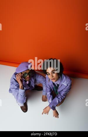 vista ad alto angolo della coppia afro-americana alla moda arancione e bianco Foto Stock