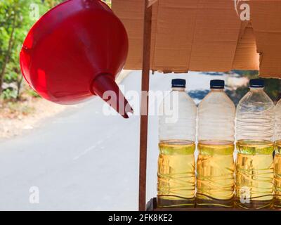 Dettaglio di una stalla con litri di benzina per auto, scooter. Il gas viene misurato in bottiglie d'acqua in plastica riutilizzate. A Bali, Indonesia. Foto Stock