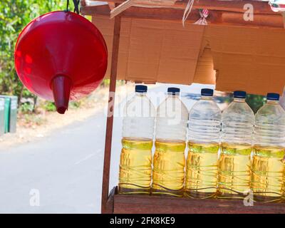 Dettaglio di una stalla con litri di benzina per auto, scooter. Il gas viene misurato in bottiglie d'acqua in plastica riutilizzate. A Bali, Indonesia. Foto Stock