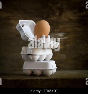 Uova singole in scatole di uova impilate l'una sull'altra Foto Stock