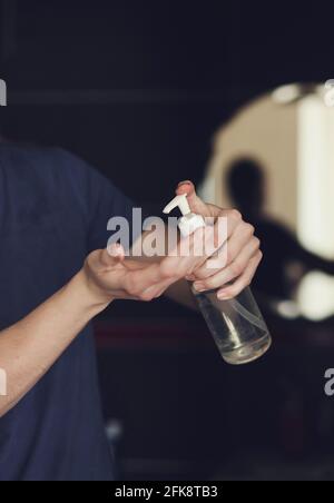 mani da uomo ravvicinate utilizzando il dispenser a pompa gel igienizzante per mani. Foto Stock