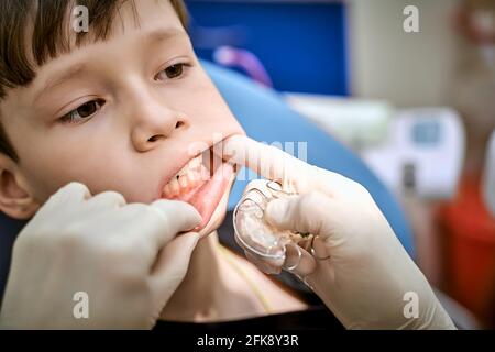 un bambino in una sedia dentista su appuntamento di un medico Foto Stock