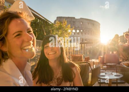 Due donne sorridenti al tramonto a Roma, Italia Foto Stock