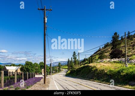 PENTICTON, CANADA - 04 LUGLIO 2020: Strada di campagna in piccola città tra le aziende agricole nella Columbia Britannica. Foto Stock