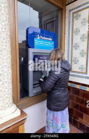 Nationwide ATM UK; una donna che riceve denaro da un servizio di cashpoint della Nationwide Bank, dal suo Flexaccount, Newmarket, Suffolk UK Foto Stock