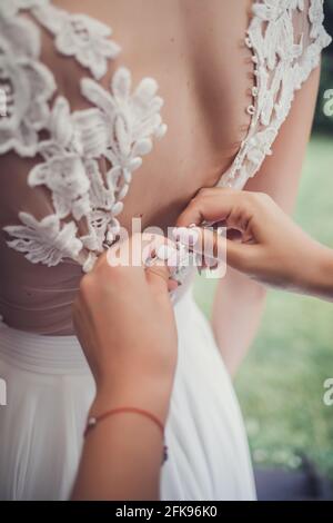 Splendida sposa in bianco abito di lusso è sempre pronto per il matrimonio. Preparazione mattutina. Foto Stock