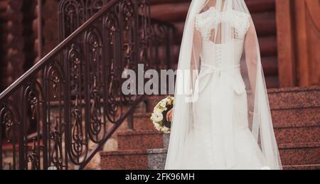 schiena sposa in pizzo abito con bouquet. copyspace Foto Stock