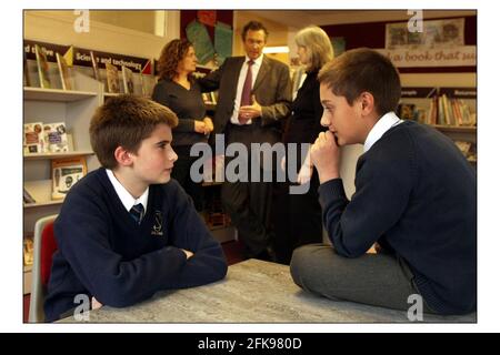 Richard Baker (11) sinistra e Charles Myristic (10) destra che sono entrambi più vecchi dell'età standard degli allievi nel loro gruppo di anno nella loro scuola, Osidge Primary School, Southgate Londra. Le loro madri Clair Baker (capelli grigi) e Tania myristic parlano al Headteacherr Peter Kent.pic David Sandison 4/5/2004 Foto Stock