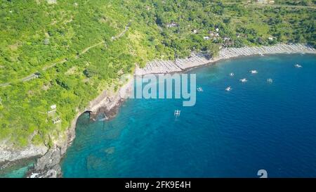 Grotte sulla riva rocciosa. Paradiso tropicale a Bali. Drone aereo Visualizza una grotta sulla costa di Bali Foto Stock