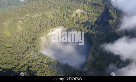 Nuvole al vulcano Kelimutu, Flores, nebbia bianca che galleggia in un cratere sul lago delle anime degli antichi abitanti di Abutu Foto Stock