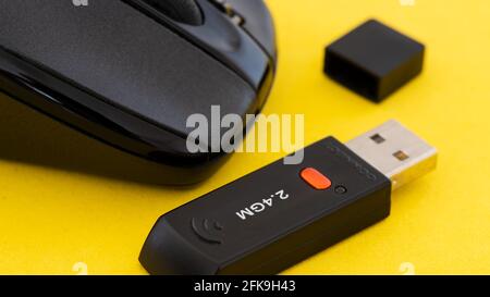 Mouse per computer wireless con adattatore wifi su sfondo giallo. Foto Stock