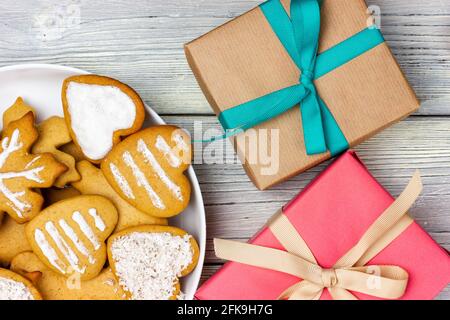 Biscotti natalizi su un piatto e diverse confezioni regalo. Regali di Natale. Foto Stock