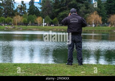 poliziotto che parla al telefono sullo sfondo del lago Foto Stock