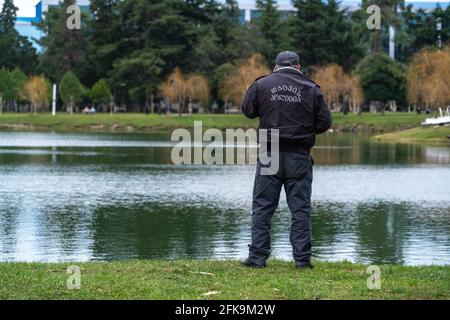 poliziotto che parla al telefono sullo sfondo del lago Foto Stock