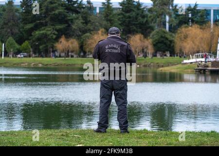 poliziotto che parla al telefono sullo sfondo del lago Foto Stock