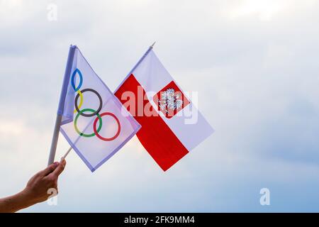 Fan sventolando la bandiera nazionale della Polonia e la bandiera olimpica con anelli simbolo olimpiadi. Foto Stock