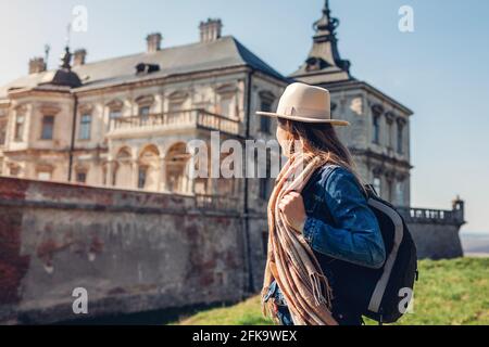 Donna turistica gode di vista sul castello di Pidhirtsi. Viaggia verso i luoghi di interesse storico, l'antica architettura e i monumenti storici dell'Ucraina occidentale. Foto Stock