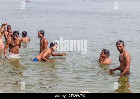 VARANASI, INDIA - 25 OTTOBRE 2016: La gente locale lava il themself in acqua sacra di Gange rover ad un Ghat scalini sul lungofiume a Varanasi, India Foto Stock