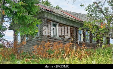 Vecchia casa in legno nella regione di Arkhangelsk, una casa residenziale villaggio in un villaggio forestale, persone abbandonate e a bordo casa. Russia Foto Stock