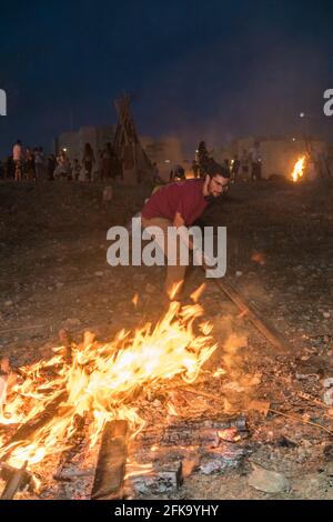 Persone che fanno fuoco durante la festa ebraica di Lag Ba'Omer, che si svolge ogni 18 del mese ebraico Iyar. È consuetudine durante questa vacanza fare incendi. Quest'anno, a causa del pericolo di incendio, tutti gli incendi sono stati concentrati in pochi siti, da cui il gran numero di piri. Foto Stock