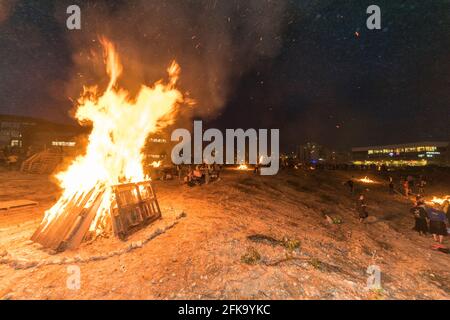 Una grande pira brucia durante la festa ebraica di Lag Ba'Omer, che si svolge ogni 18 del mese ebraico Iyar. È consuetudine durante questa vacanza fare incendi. Quest'anno, a causa del pericolo di incendio, tutti gli incendi sono stati concentrati in pochi siti, da cui il gran numero di piri, che si può vedere in background. Foto Stock