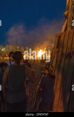 Persone che fanno fuoco durante la festa ebraica di Lag Ba'Omer, che si svolge ogni 18 del mese ebraico Iyar. È consuetudine durante questa vacanza fare incendi. Quest'anno, a causa del pericolo di incendio, tutti gli incendi sono stati concentrati in pochi siti, da cui il gran numero di piri. Foto Stock