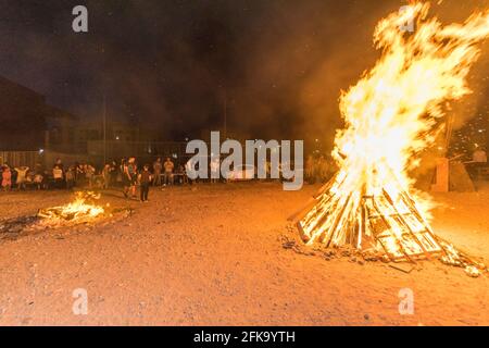 Una grande pira brucia durante la festa ebraica di Lag Ba'Omer, che si svolge ogni 18 del mese ebraico Iyar. È consuetudine durante questa vacanza fare incendi. Quest'anno, a causa del pericolo di incendio, tutti gli incendi sono stati concentrati in pochi siti, da cui il gran numero di piri, che si può vedere in background. Foto Stock