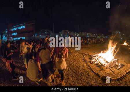 Persone che fanno fuoco durante la festa ebraica di Lag Ba'Omer, che si svolge ogni 18 del mese ebraico Iyar. È consuetudine durante questa vacanza fare incendi. Quest'anno, a causa del pericolo di incendio, tutti gli incendi sono stati concentrati in pochi siti, da cui il gran numero di piri. Foto Stock