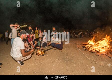 Un gruppo di giovani ragazze prepara i marshmellows su un piccolo fuoco durante la festa ebraica di Lag Ba'Omer, che si svolge ogni 18 del mese ebraico Iyar. È consuetudine durante questa vacanza fare incendi. Quest'anno, a causa del pericolo di incendio, tutti gli incendi sono stati concentrati in pochi siti, da cui il gran numero di piri. Foto Stock