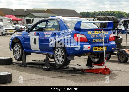 Richard Burns Memorial Rally a RAF Marham, Norfolk, UK, con la gara 2004 Subaru Impreza WRX STi su jack in pit area. Auto da rally di Damien Rigden Foto Stock